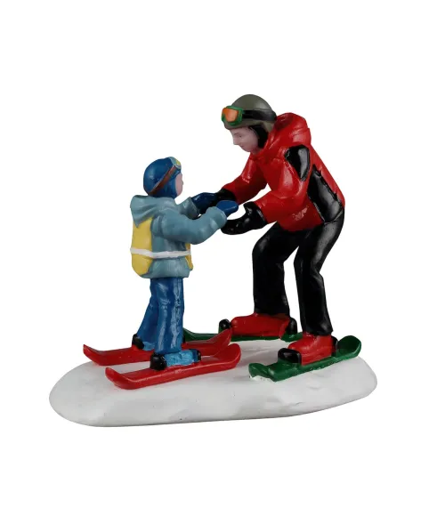 Lemax Ski Slope Lesson 62627: maestro di sci con bambino durante la prima lezione sugli sci