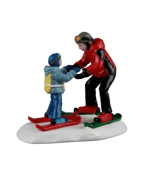 Lemax Ski Slope Lesson 62627: maestro di sci con bambino durante la prima lezione sugli sci